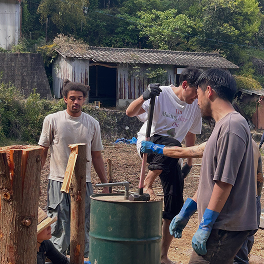 屋外で道具を使い、作業をする人たち