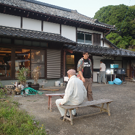古民家の前のベンチで過ごす人たち