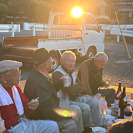 夕日を浴びながら屋外で集まる人たち